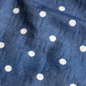 Coupon 35cm chambray geborduurde stippen wit